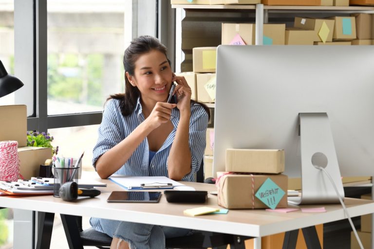 Femme au téléphone devant son ordinateur